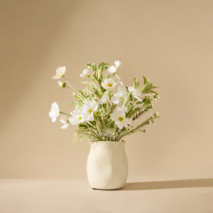 White flowers in a vase on a beige background